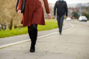 two people walking on a pavement