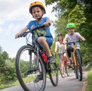 Female cycling with two young children